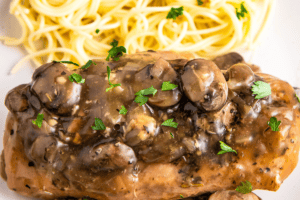 A plate with chicken marsala and spaghetti on it