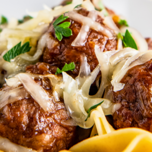 Close up of meatballs and cheese on top of pasta