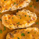 Overhead view of three chicken breasts covered in gravy
