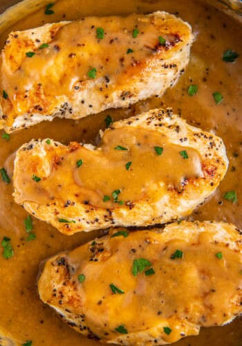 Overhead view of three chicken breasts covered in gravy