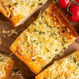 Three slices of garlic bread next to cherry tomatoes