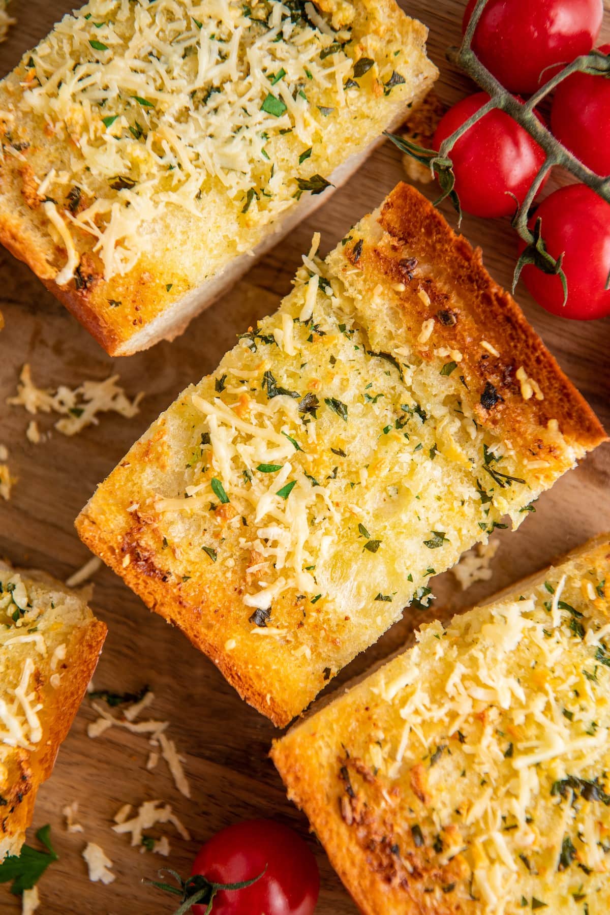 Three slices of garlic bread next to cherry tomatoes