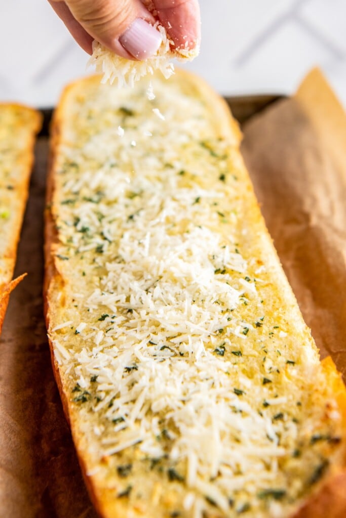 Close up of unmelted cheese on top of garlic bread