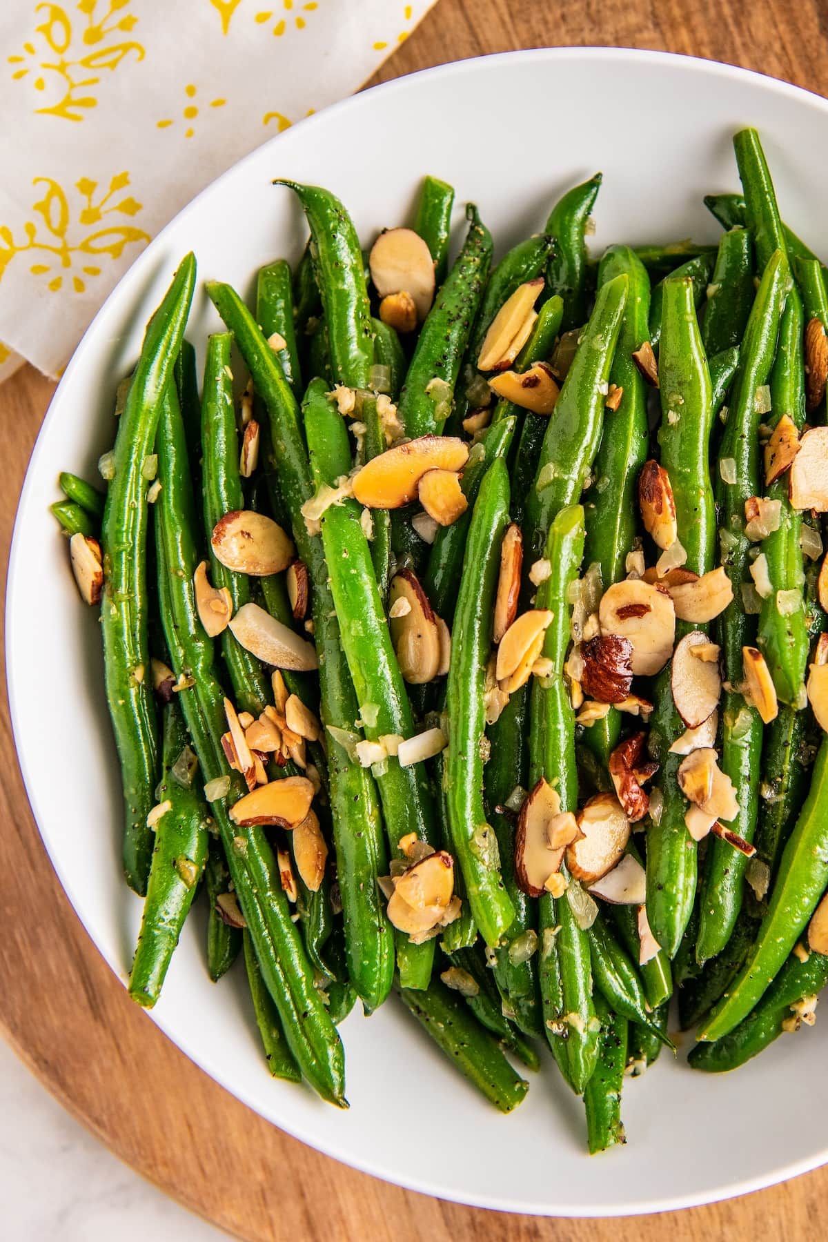 Close up of green beans topped with almonds on a plate