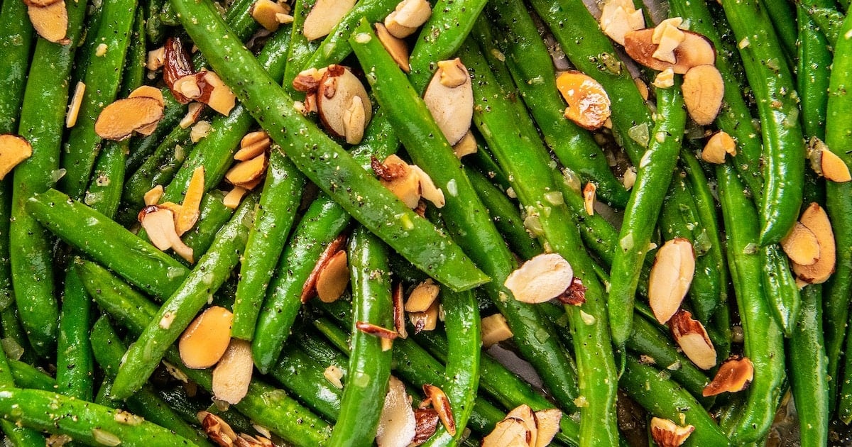 Close up overhead view of green beans topped with almonds