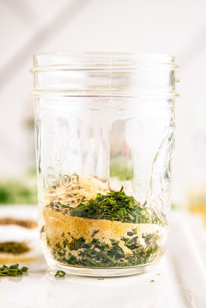 A mason jar with a little bit of herbs and spices in it