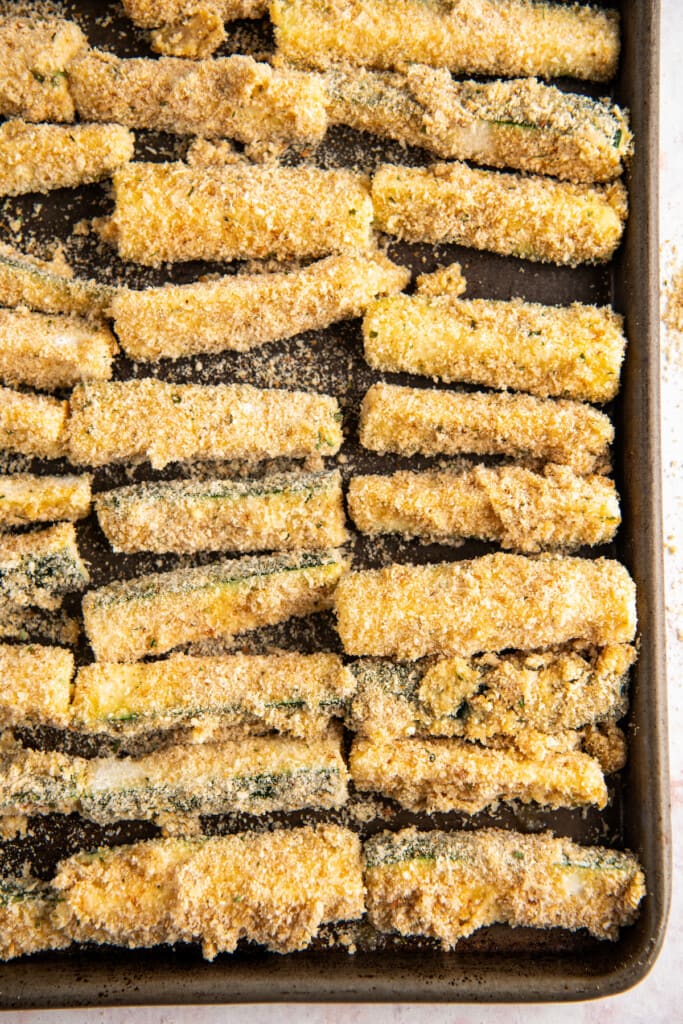 Breaded zucchini fries on a baking sheet