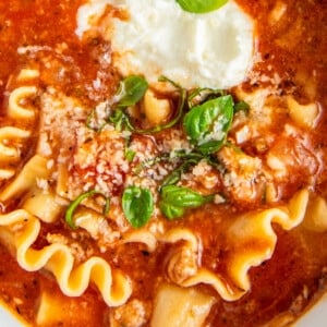 Close up overhead view of lasagna soup topped with basil and ricotta