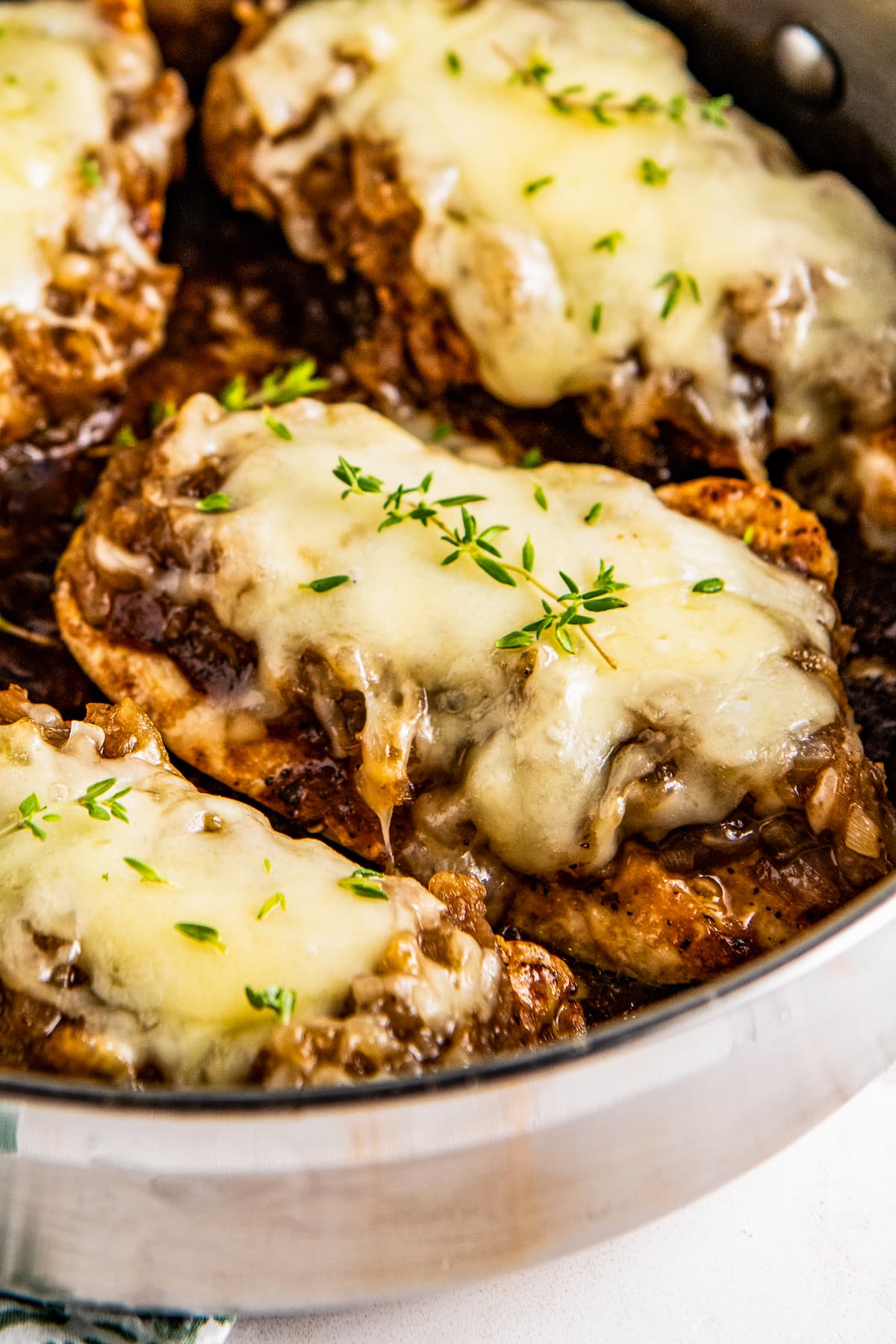 Close up of French onion chicken breasts topped with melted gruyere