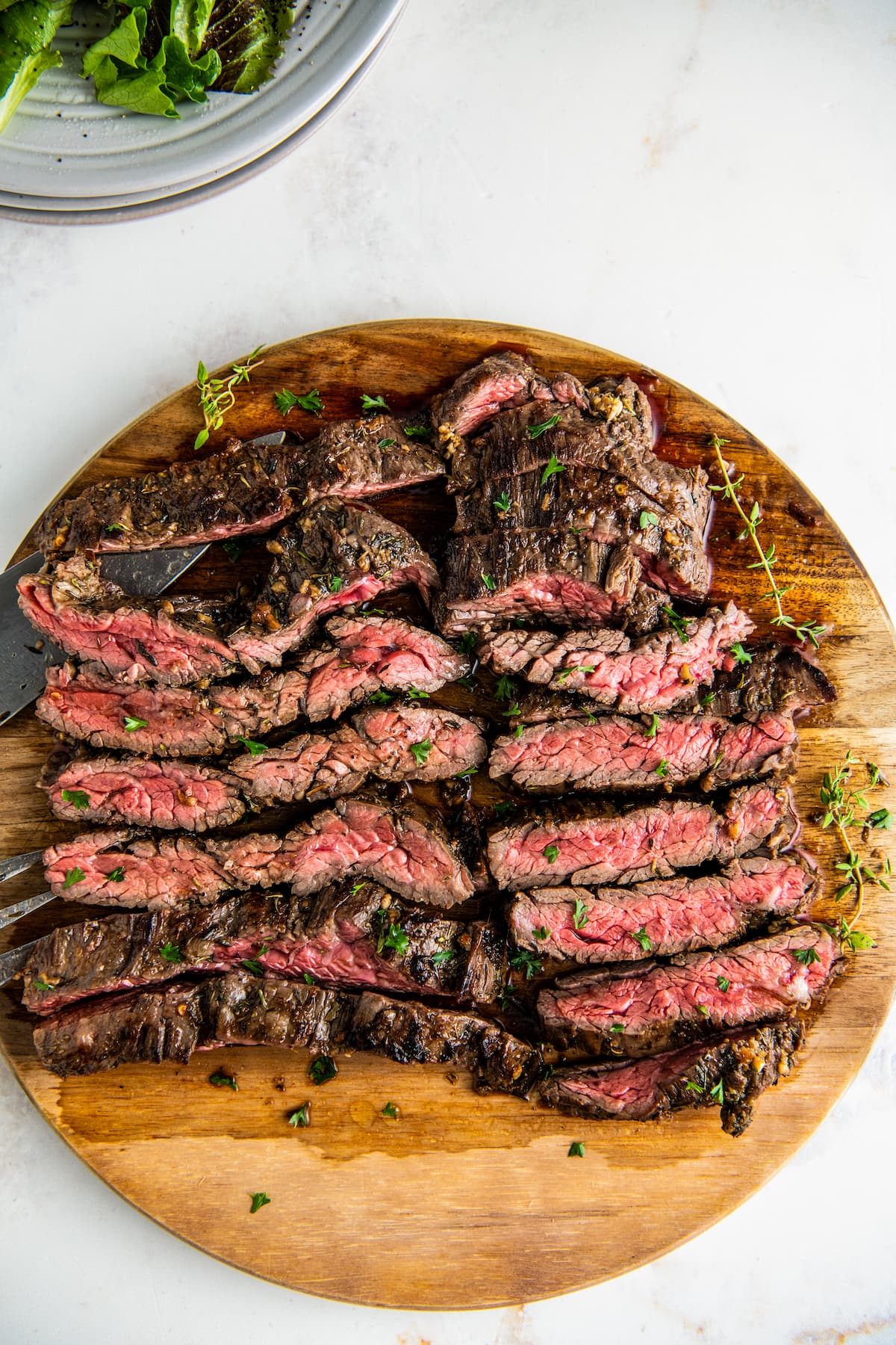 Overhead view of skirt steak resting on a cutting board, cut into slices