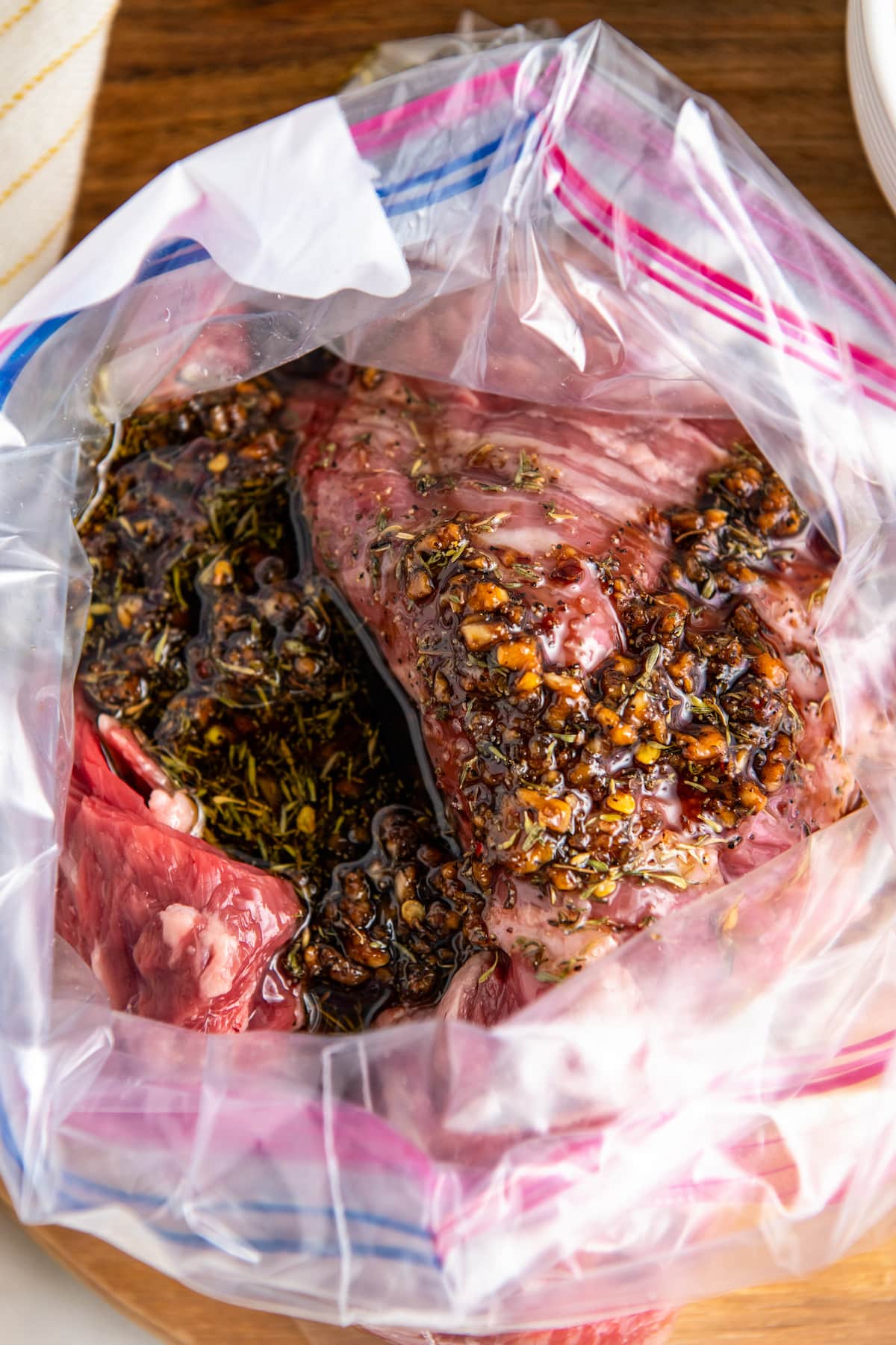 Overhead view looking into an open ziplock bag with skirt steak and marinade