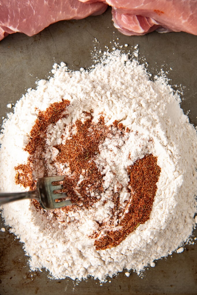 A fork stirring a spice rub with flour