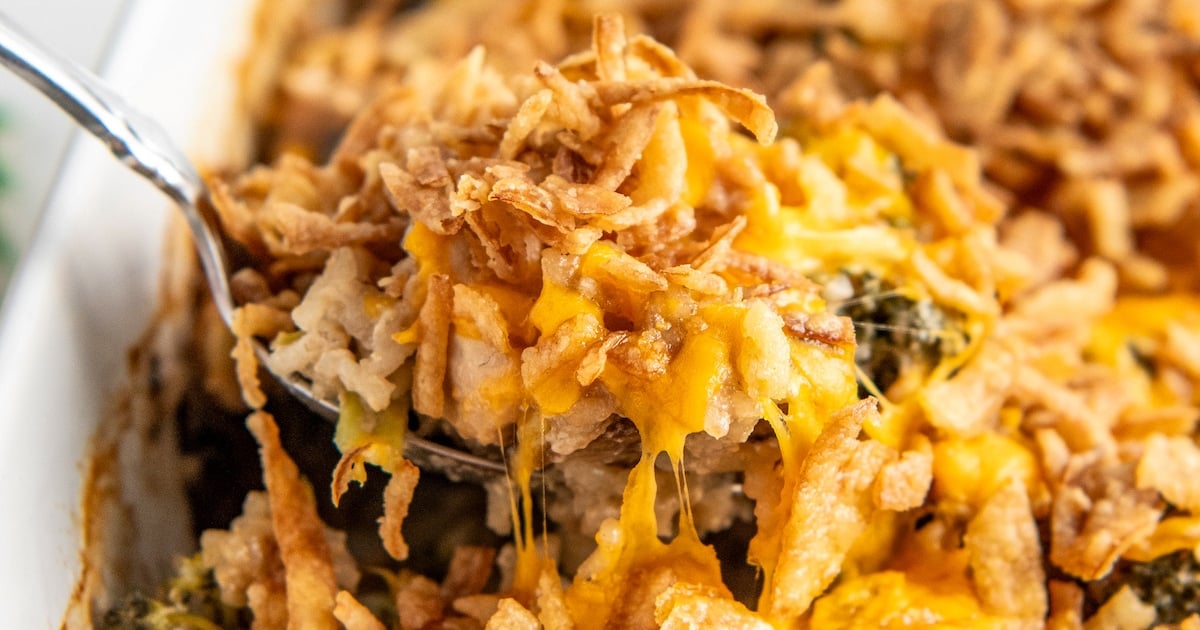 Close up of a spatula removing chicken and rice casserole from a dish