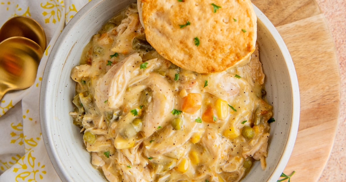 Overhead view of a bowl of chicken pot pie filling with a biscuit
