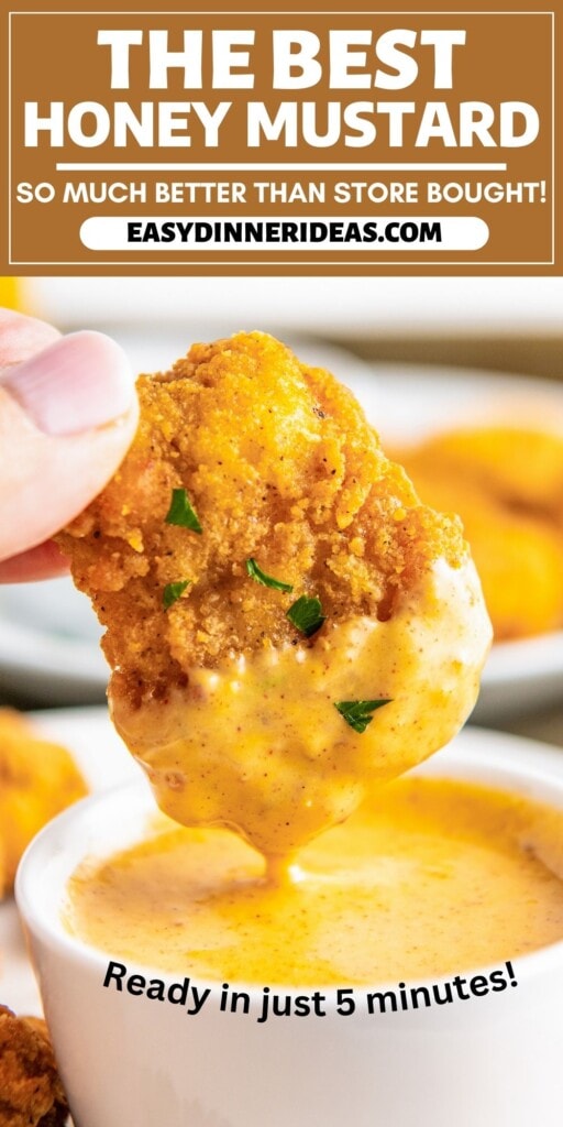 Honey mustard in a bowl with a chicken tender being dipped in it.