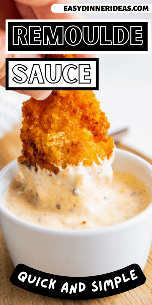 A piece of fried shrimp being dipped in a bowl of Remoulade Sauce.