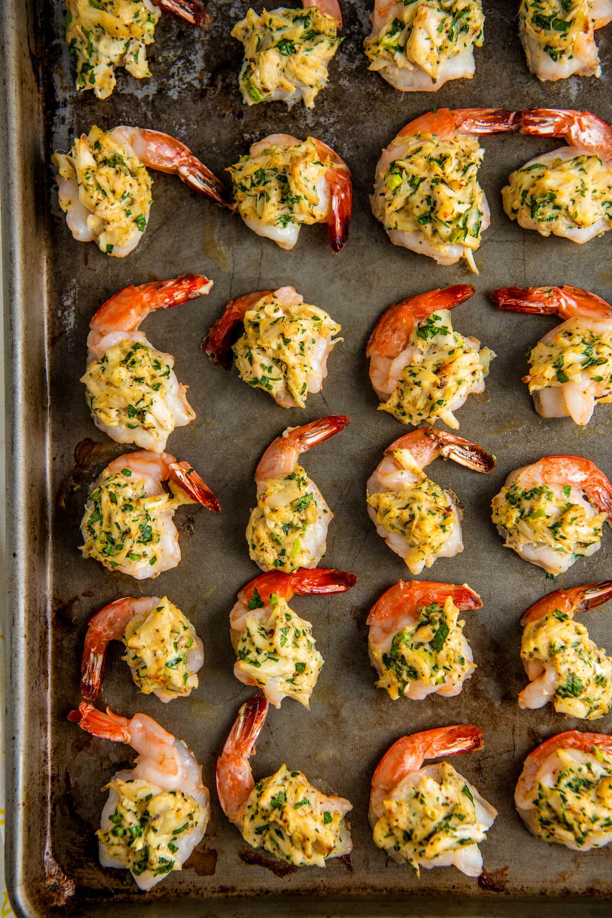 A baking sheet of shrimp with crab stuffing.