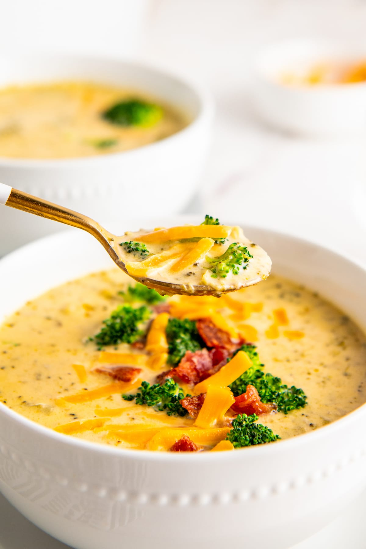 Lifting a spoonful of soup out of a bowl.