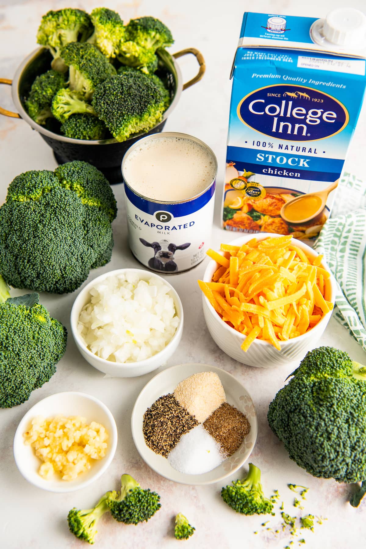 Ingredients for broccoli cheese soup, arranged on a table.