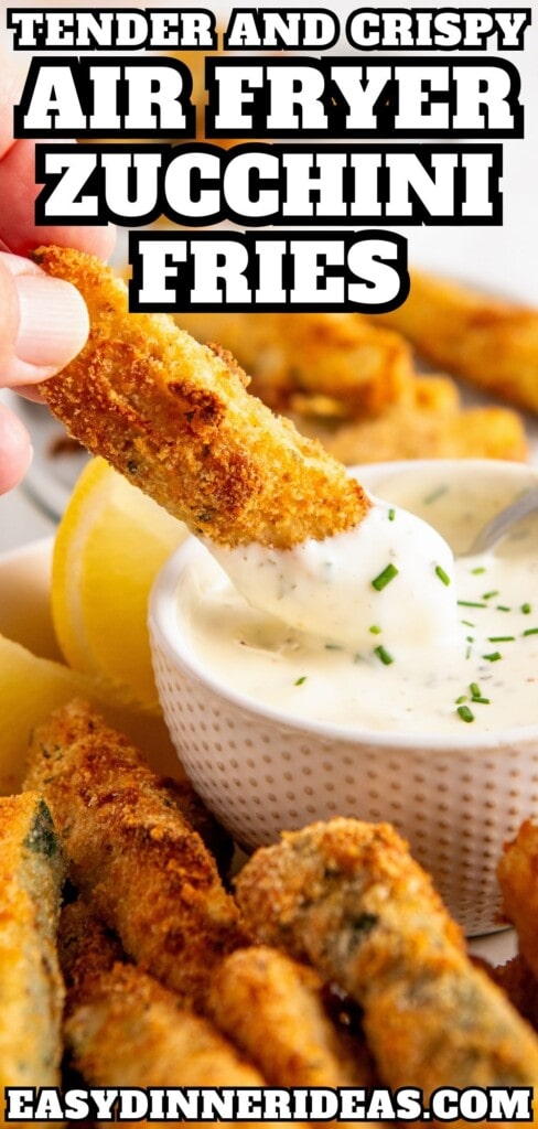 Zucchini fry being dunked into a bowl of ranch dressing.