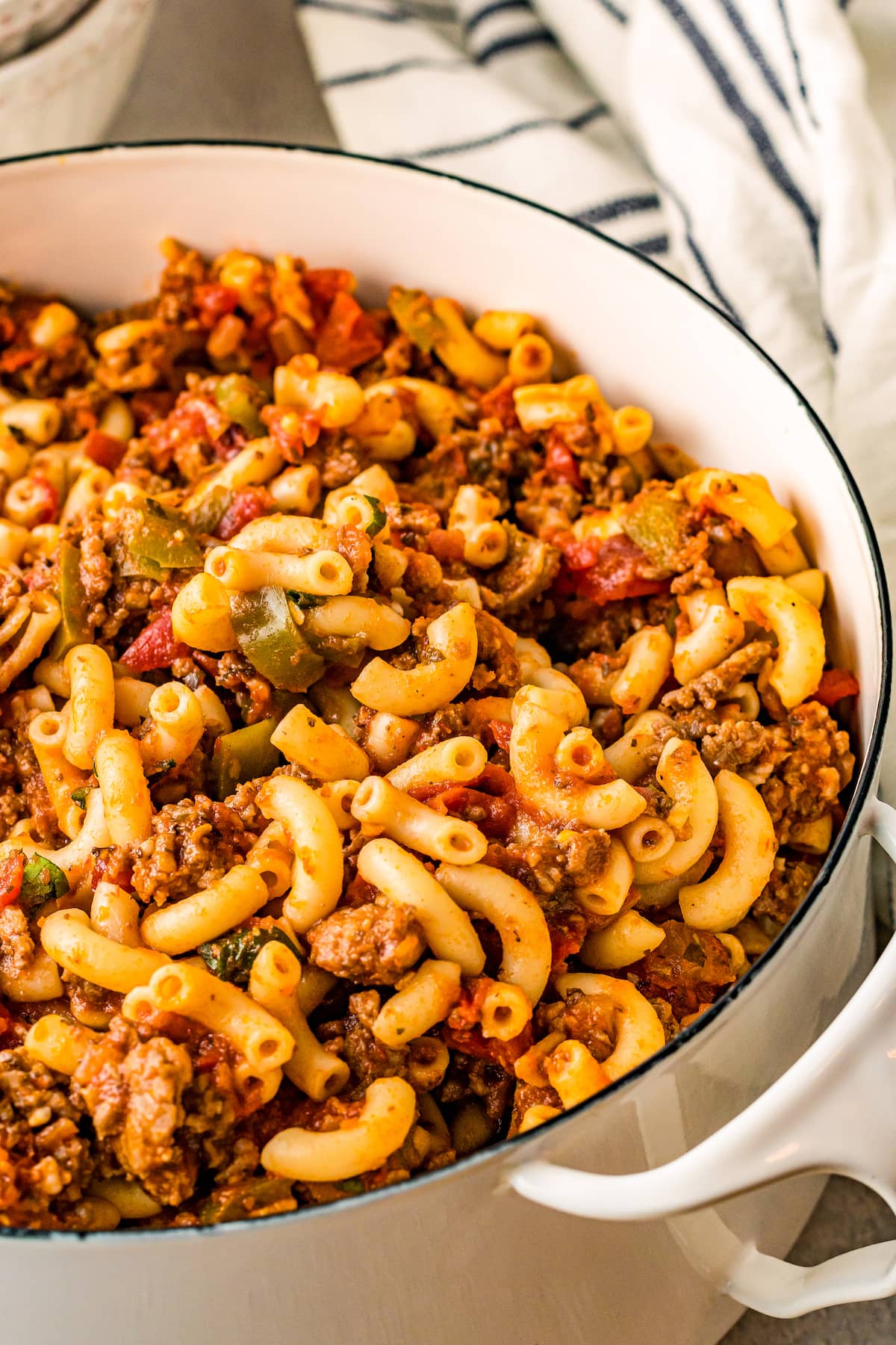 Close up of a pot filled with macaroni noodles, ground beef, and tomatoes.