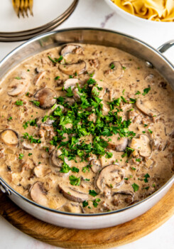A pot of mushroom and ground beef stroganoff topped with parsley.