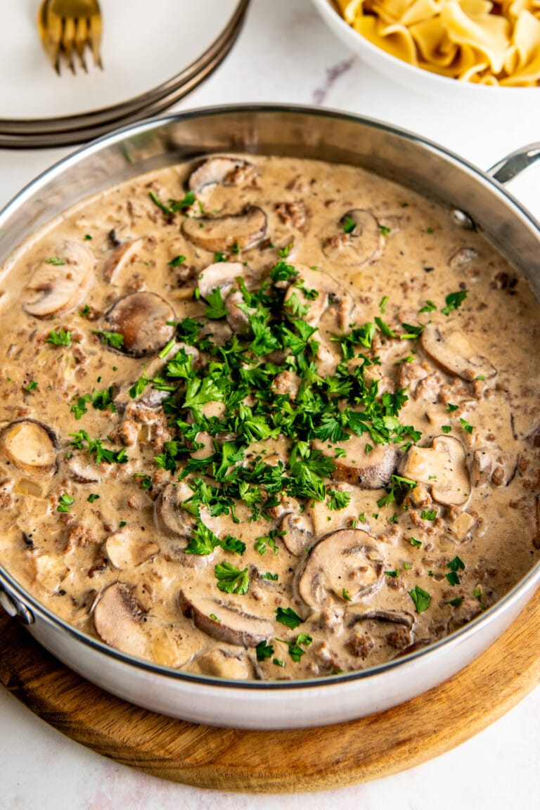 A pot of mushroom and ground beef stroganoff topped with parsley.