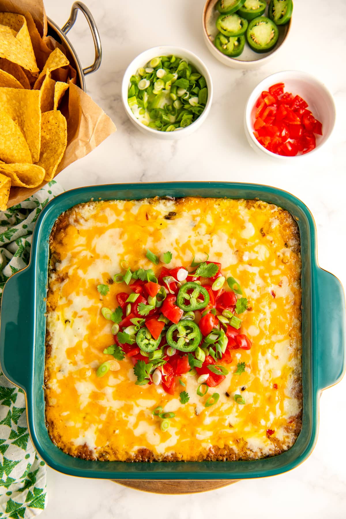 Bean dip garnished with tomatoes, jalapenos, cilantro, and green onions.