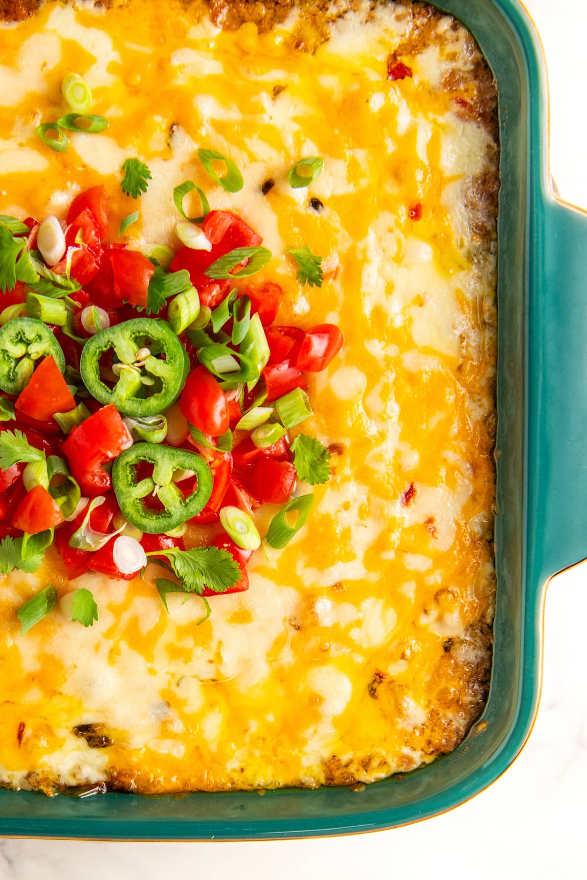 Baked bean dip topped with tomatoes, jalapenos, green onions and cilantro.