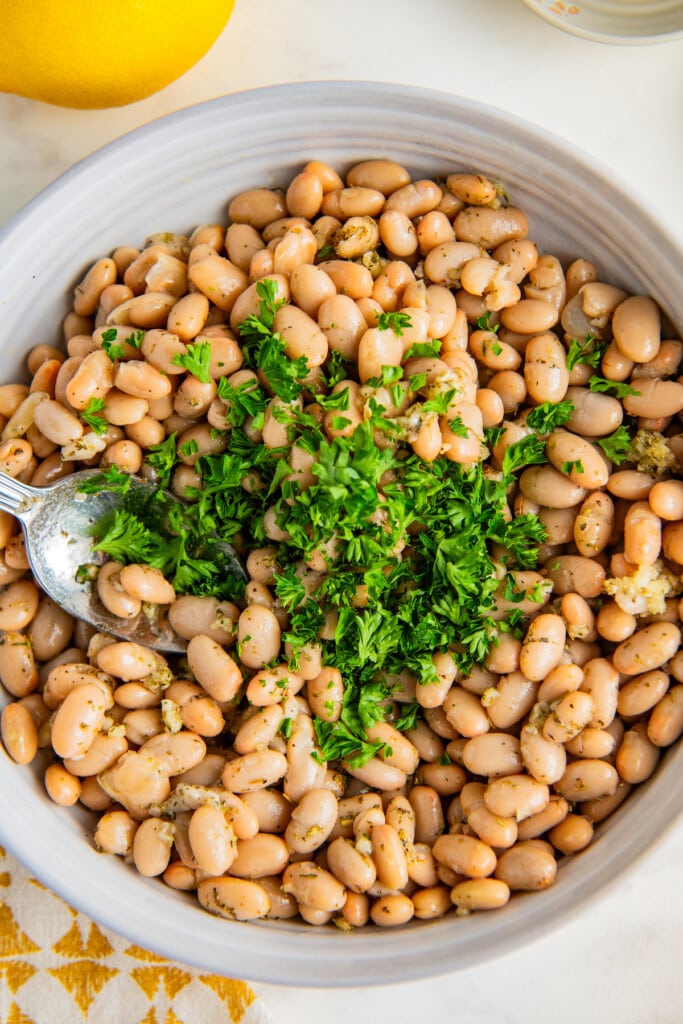 Adding parsley to the white beans.
