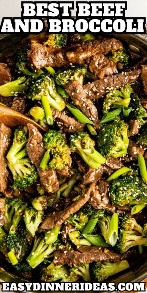 Beef and broccoli stir fry in a large skillet topped with green onions and sesame seeds.