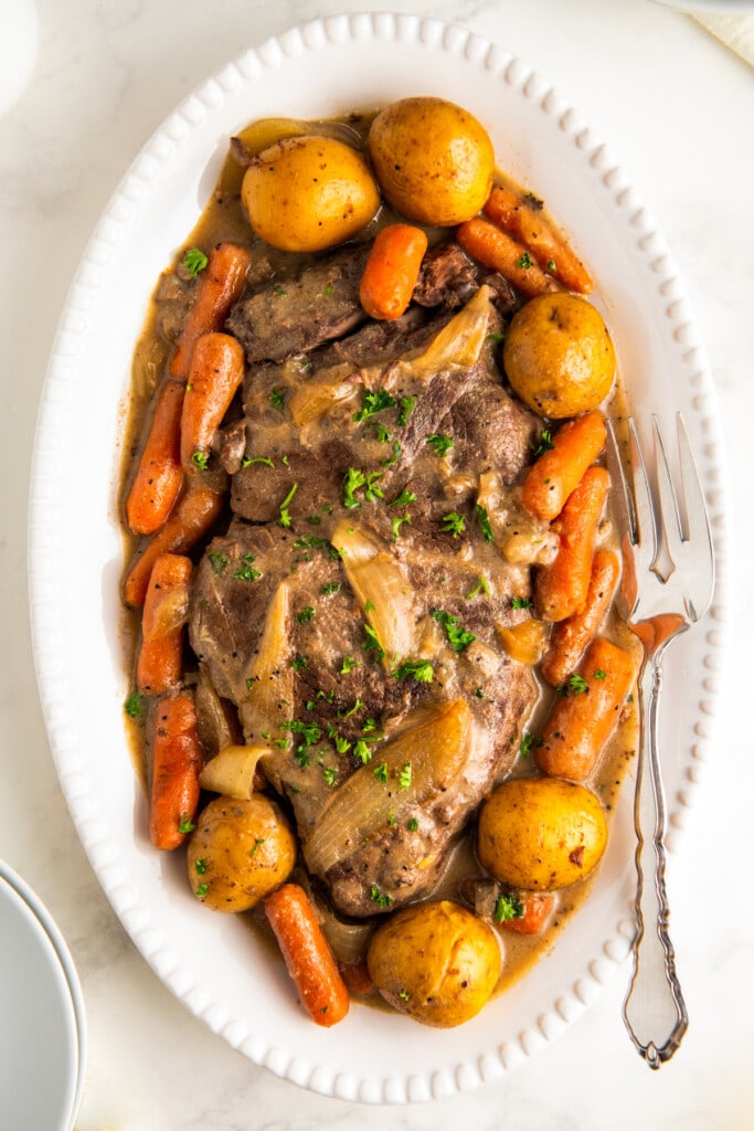 Crockpot London broil on a white serving platter.