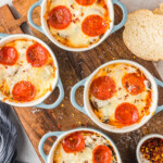 Cooked pizza bowls topped with parmesan and red pepper flakes.