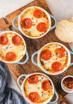 Cooked pizza bowls topped with parmesan and red pepper flakes.