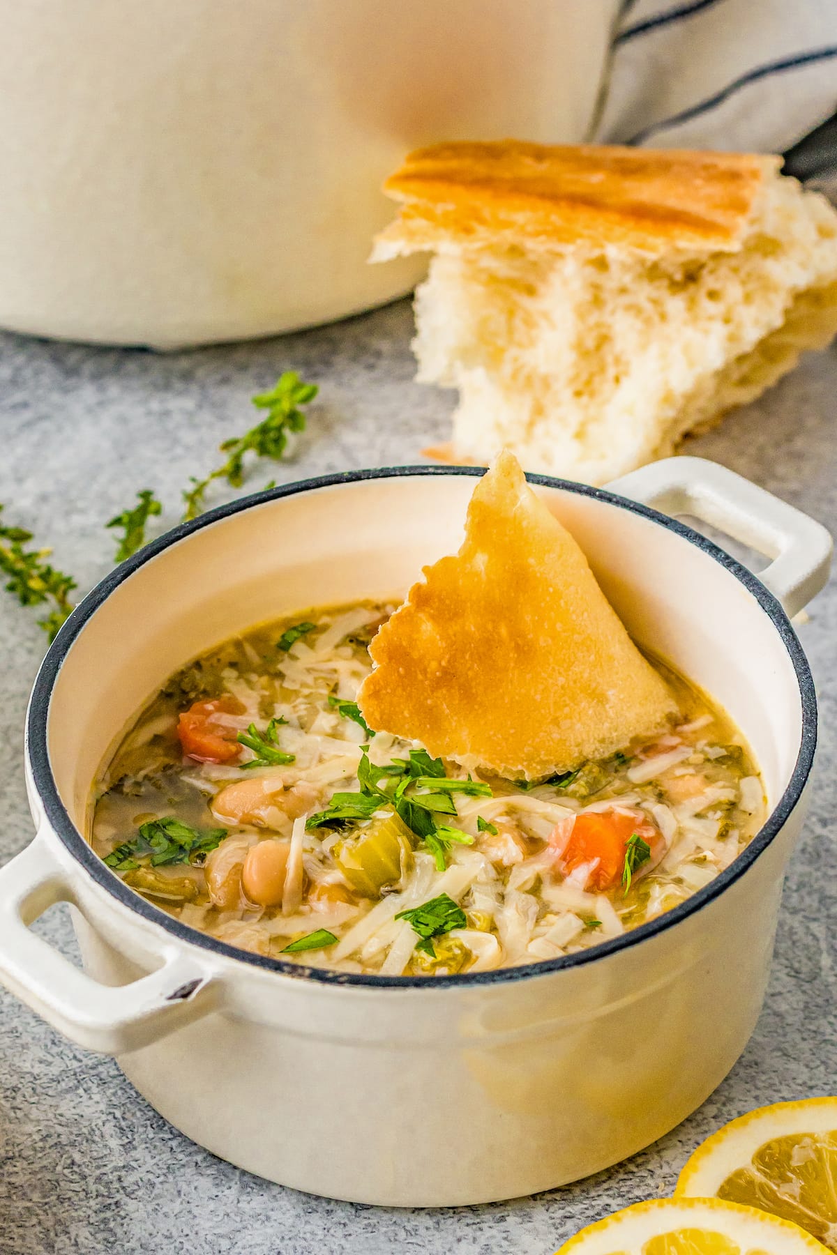 A bowl of white bean soup with a piece of bread alongside. 