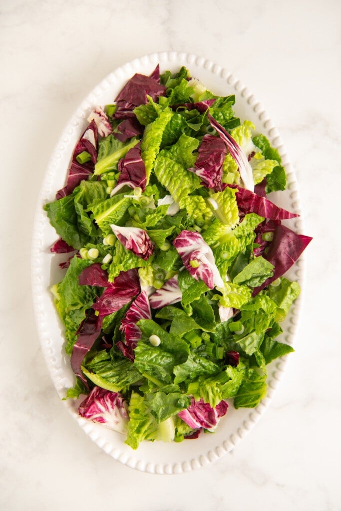 Mixed salad greens and radicchio on a white plate.