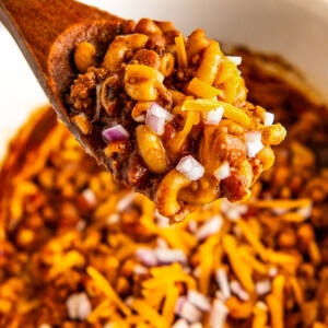 A wooden spoon serving a portion of chili mac.