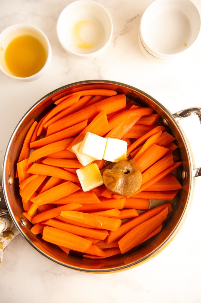 Add butter, brown sugar, orange juice, salt and honey to the tender carrots.