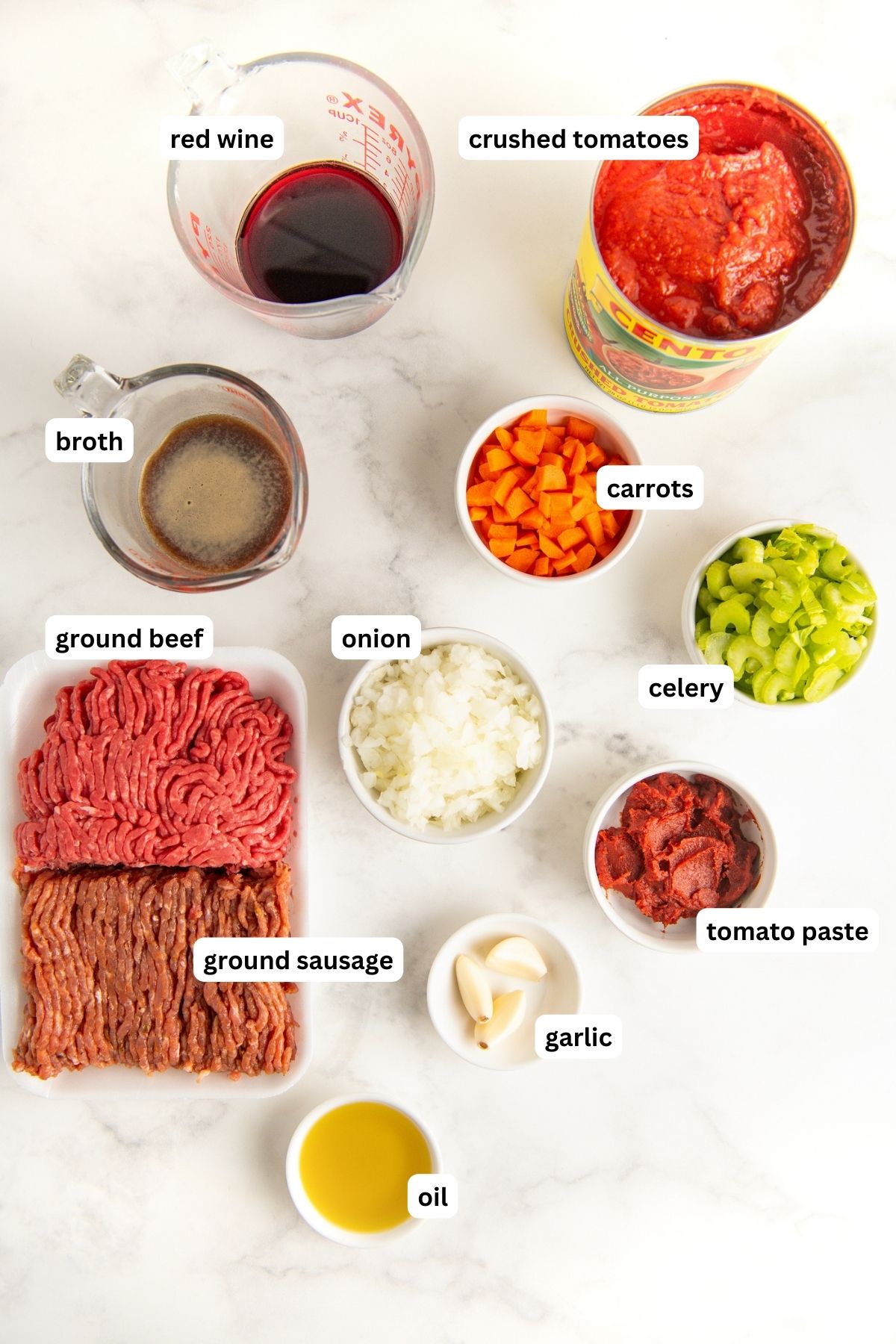 Ingredients for ragu recipe arranged in bowls, from top to bottom: red wine, crushed tomatoes, broth, carrots, ground beef, ground sausage, onion, celery, tomato sauce, garlic and oil.