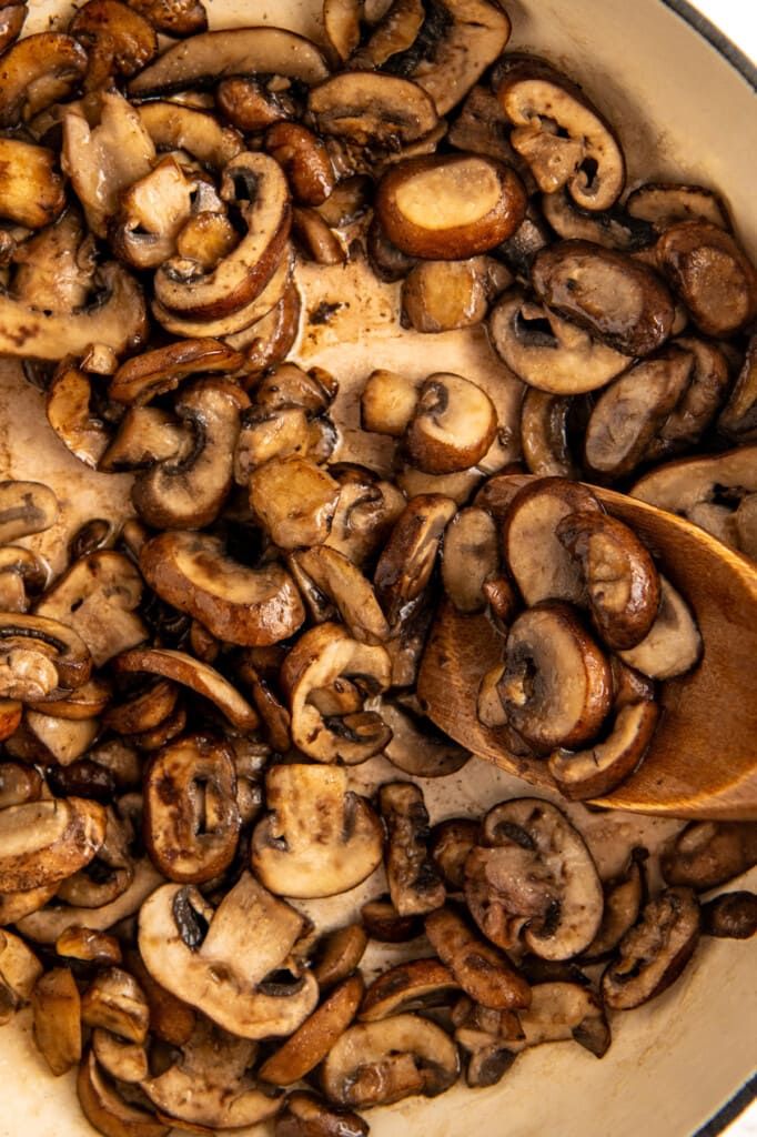 Showing how to saute mushrooms in a skillet with butter and olive oil.