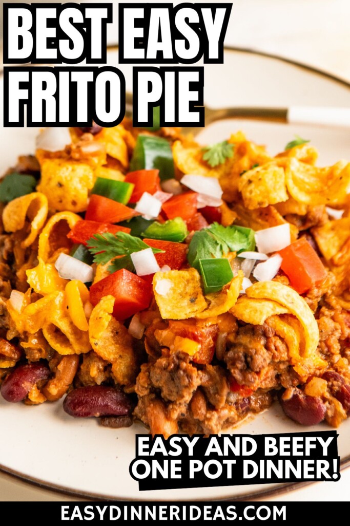 A plate filled with chili Frito pie with lots of melty cheese and beans.