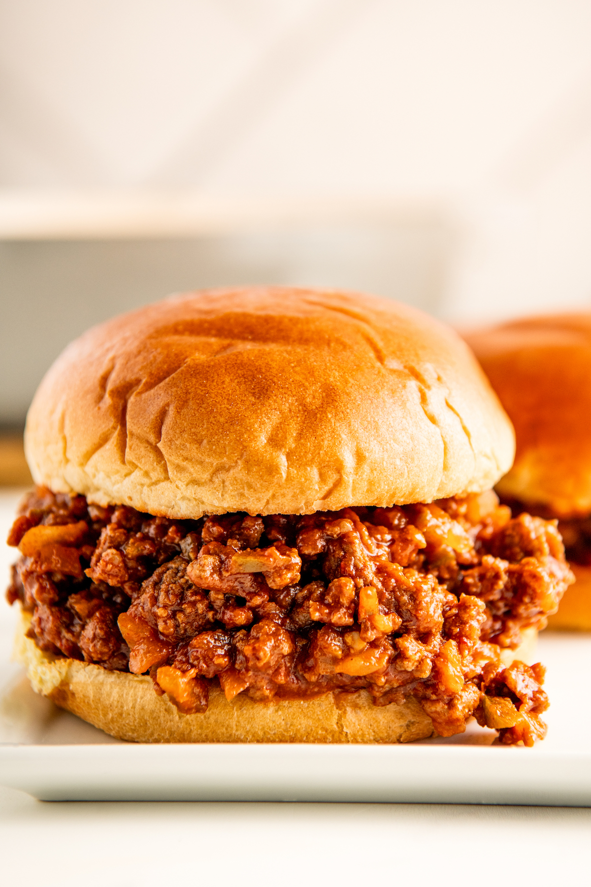 Closeup of a juicy, homemade sloppy Joe sandwich served on a toasted bun.