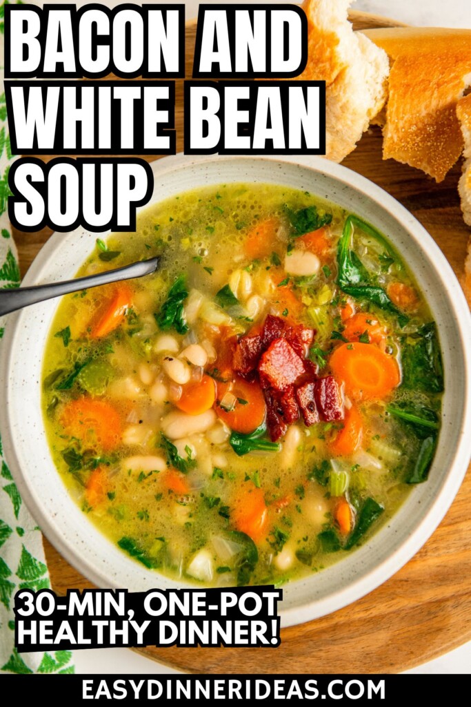 Tender white bean and bacon soup in a bowl with fresh herbs on top and crusty bread on the side.