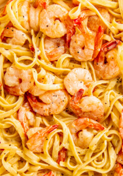 Creamy lemon garlic shrimp pasta in a skillet with juicy and buttery shrimp and fettuccine noodles in a parmesan cream sauce.