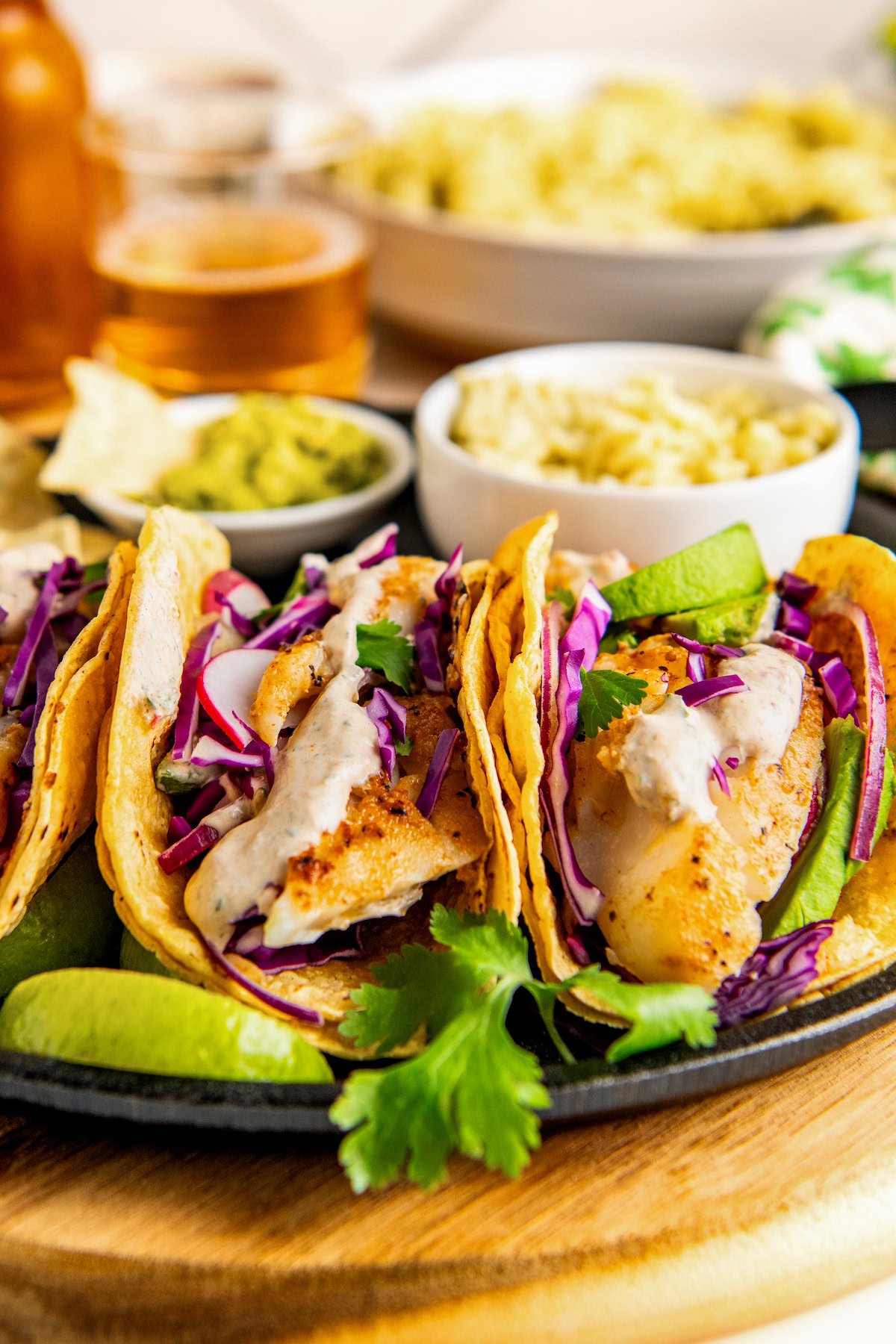 Prepared easy fish tacos with avocado, radishes, cabbage, and a creamy fish taco sauce. 