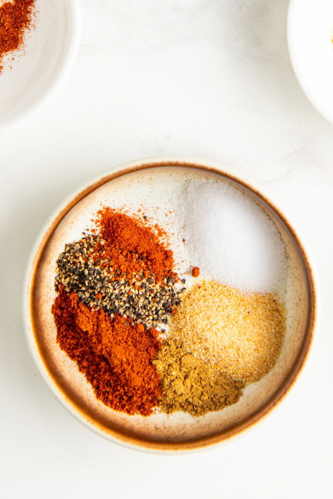 Adding the spices and seasonings to a bowl to make the fish taco seasoning mix.