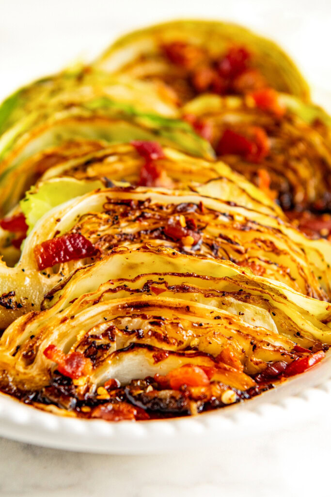 Close-up of sliced cabbage with hot honey, cooking juices, and smokey bacon.