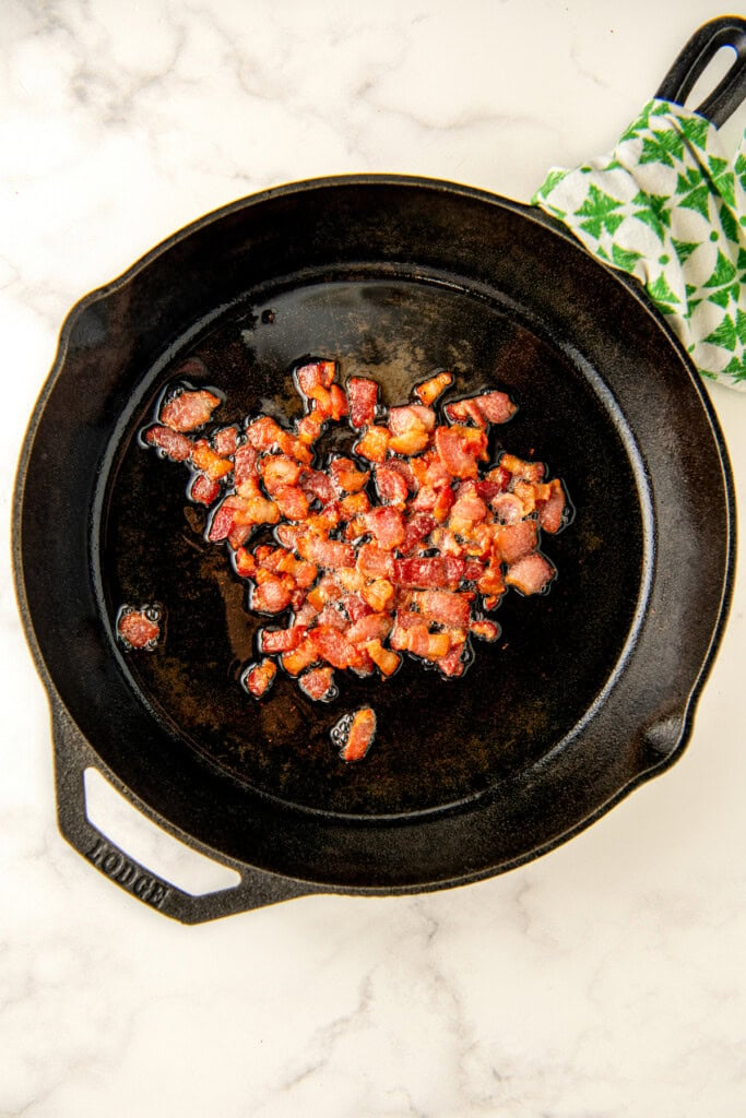 Cooking the bacon in the skillet. 