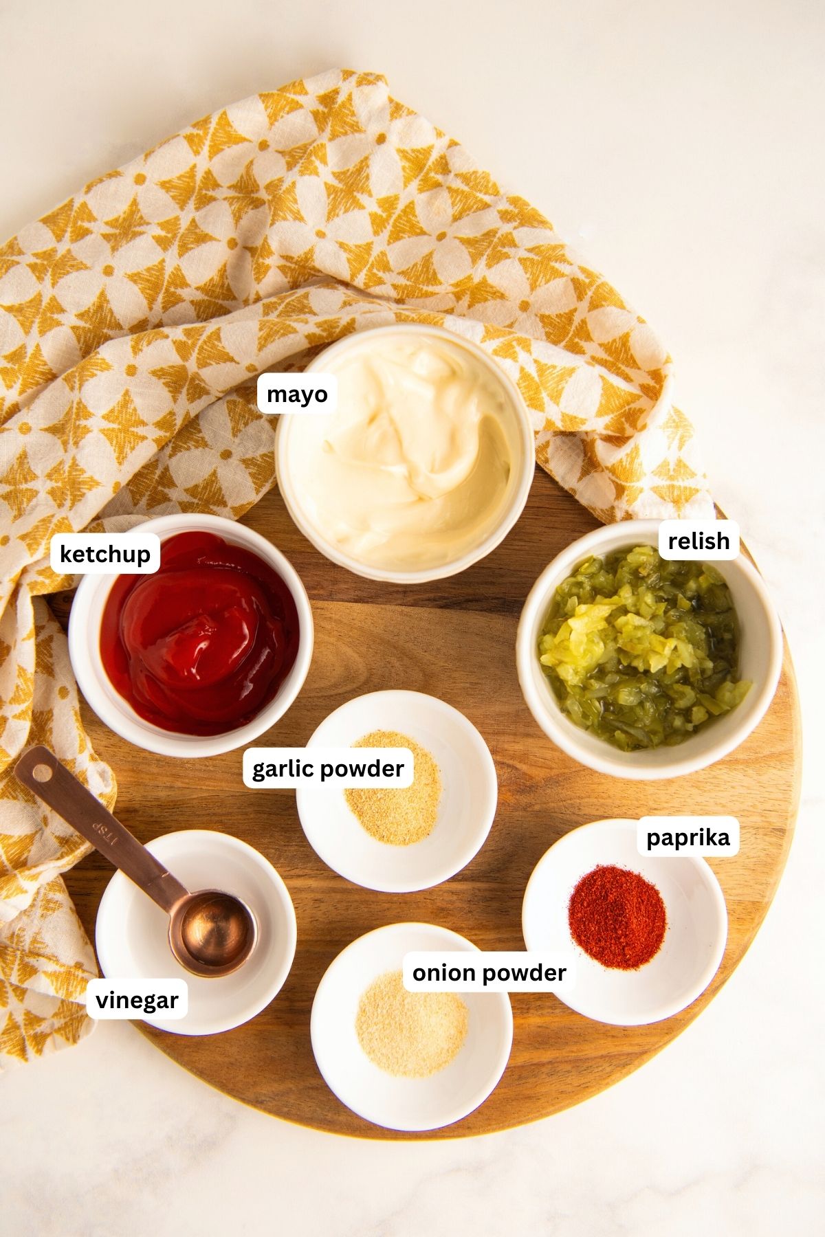 Ingredients for copycat In-N-Out sauce recipe arranged in bowls. From top to bottom: mayo, ketchup, relish, garlic powder, vinegar, paprika and onion powder.