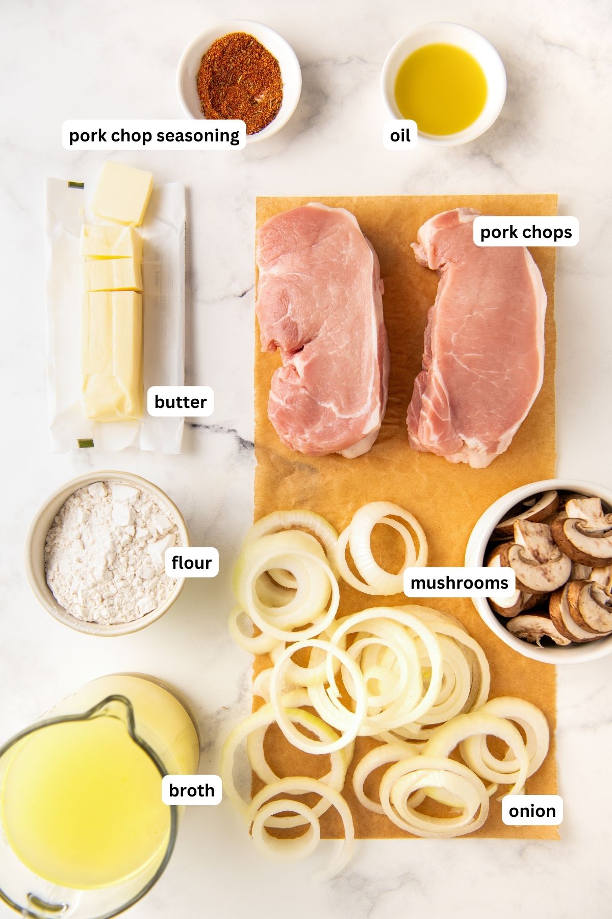 Ingredients for smothered pork chops recipe arranged in bowls. From top to bottom: pork chop seasoning, oil, butter, pork chops, flour, mushrooms, onion and broth.